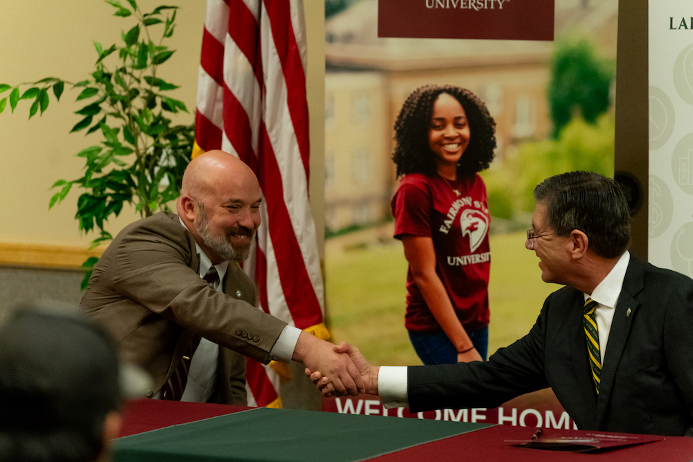 Fairmont State University President Michael Davis, Ph.D., at left, and WVSOM President James W. Nemitz, Ph.D.,  shake hands on POMP agreement