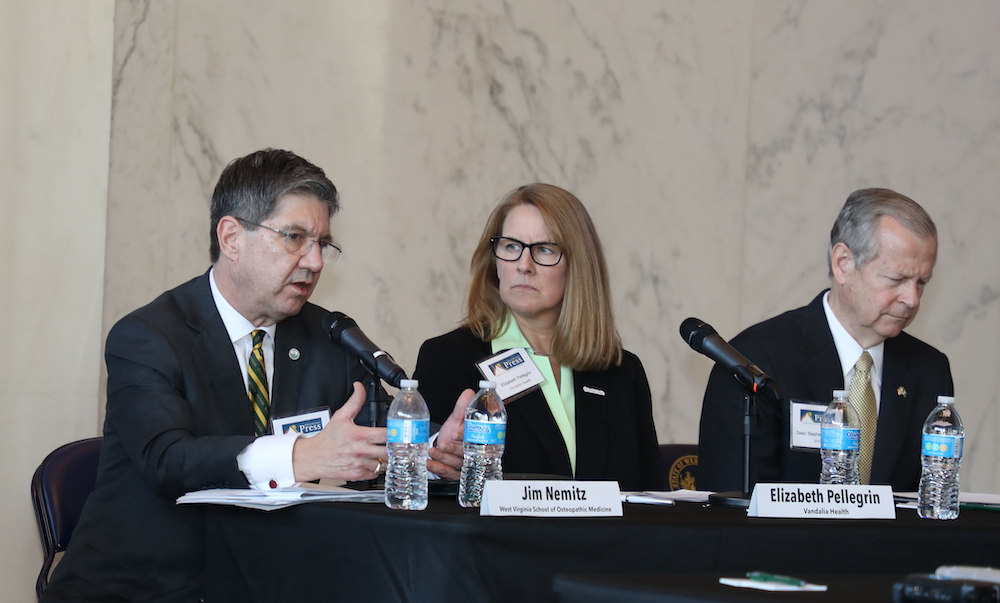 Dr. James Nemitz, seated, joins two other panelists at a table during the 2024 Legislative LookAhead