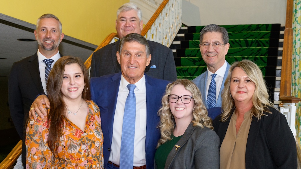 Seven people, four in front, three in back, pose for a photo