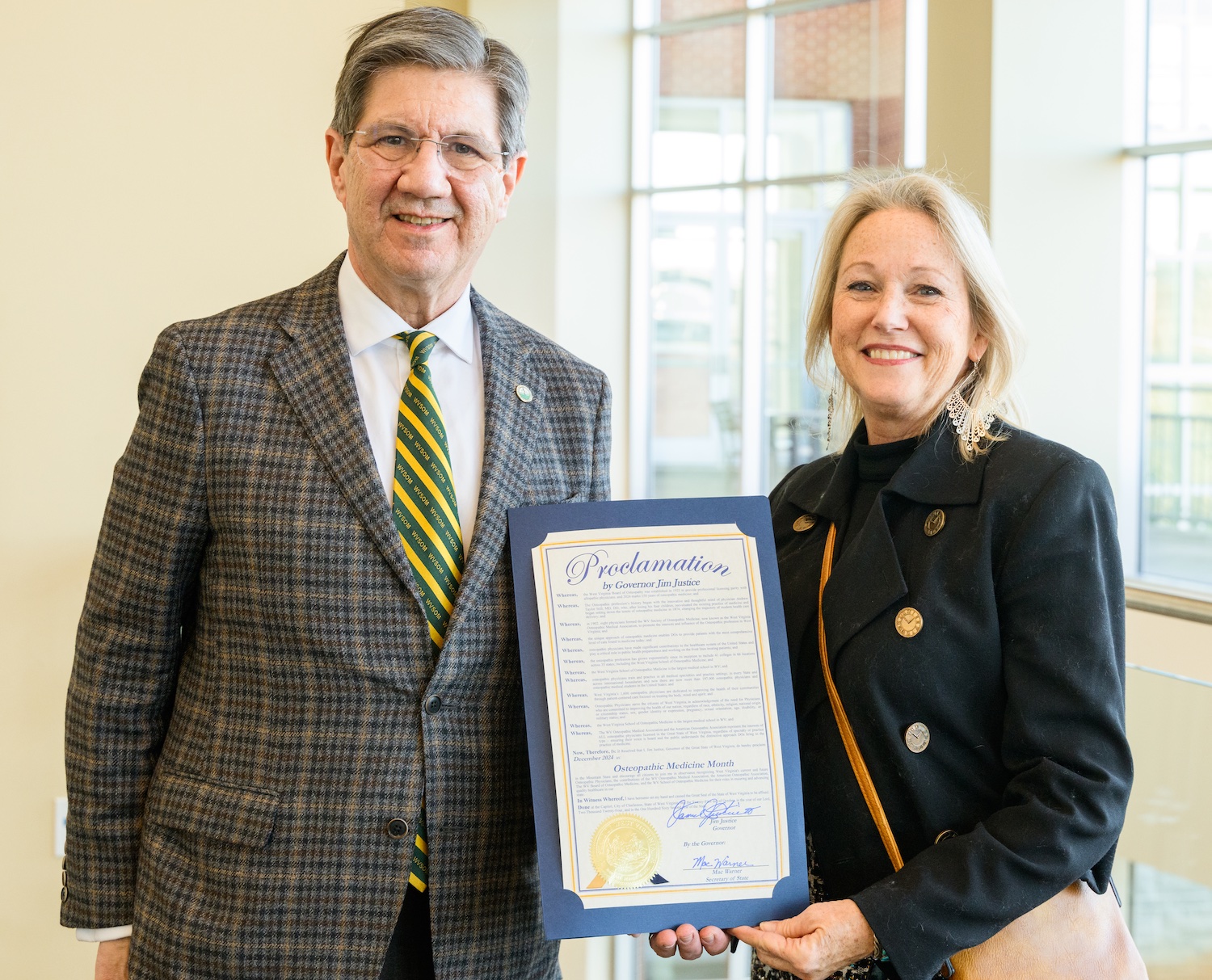 A man and woman hold a certificate 