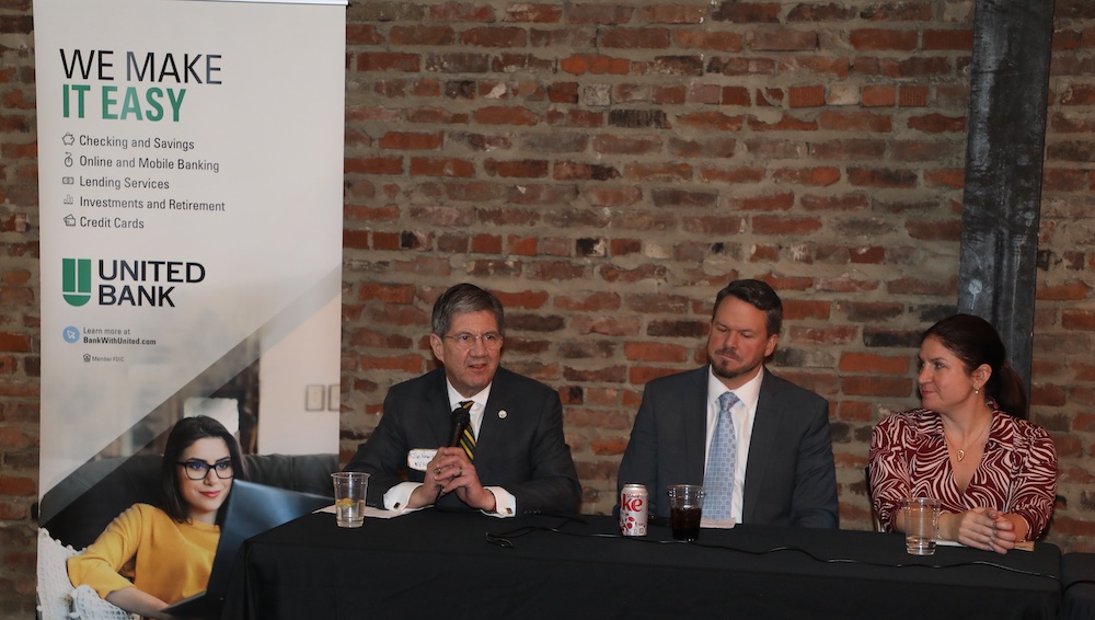 Two men and a woman sit at a table. 