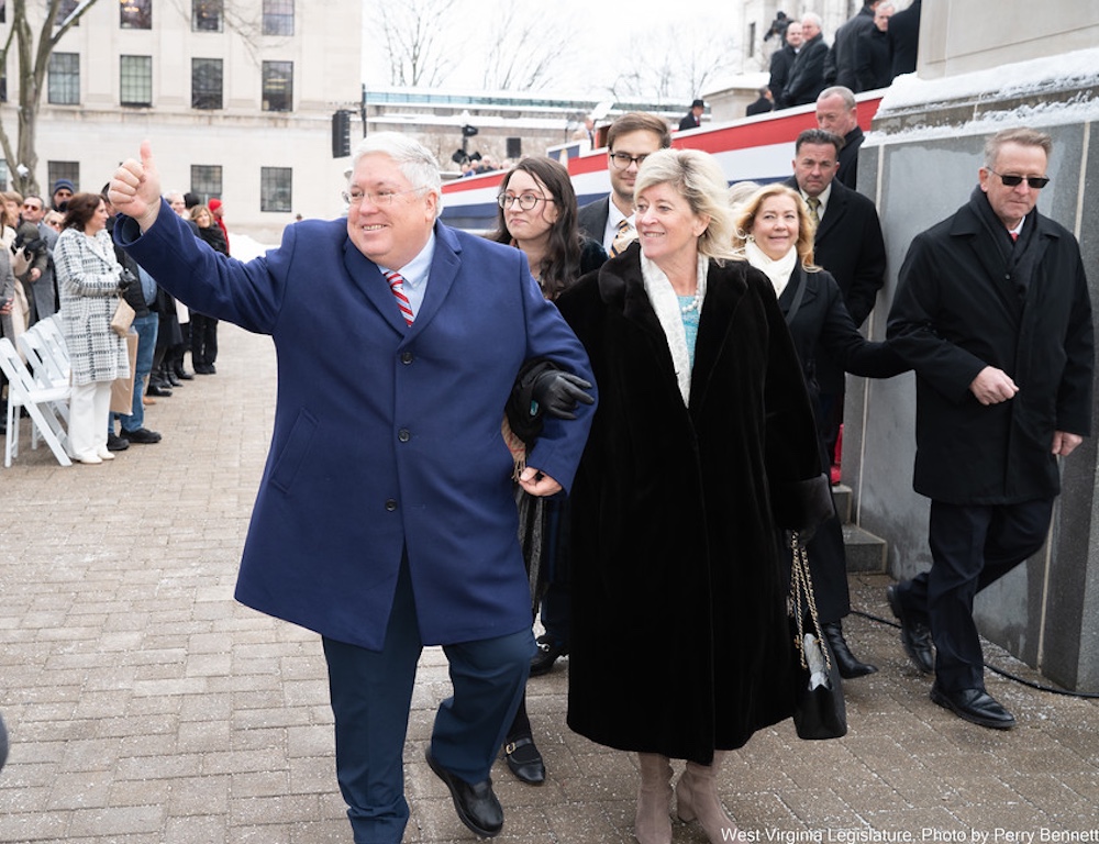 Man and woman wave to people