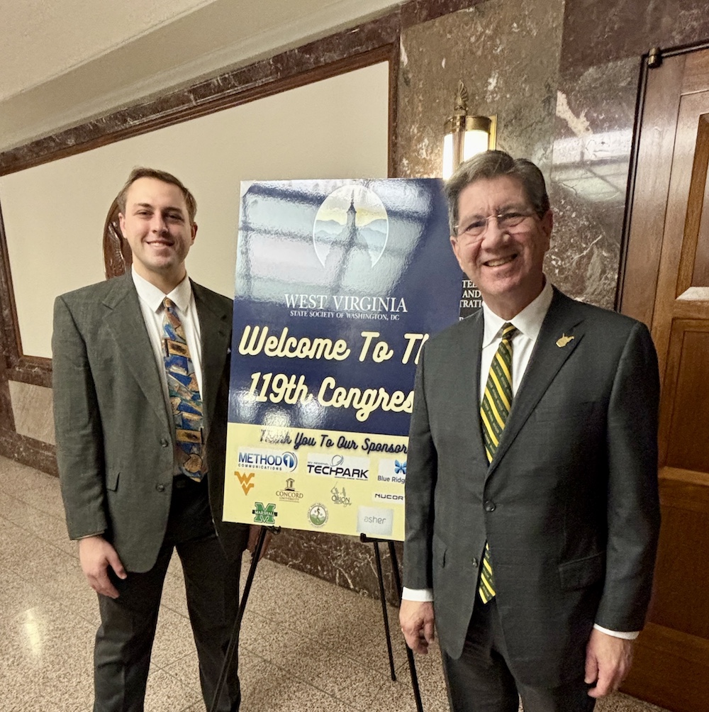 Two men stand around a sign