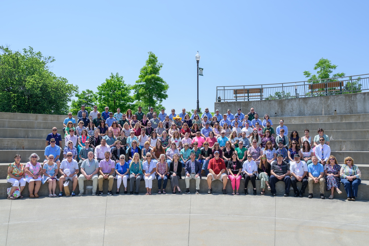 A large group of people seated in rows outdoors.