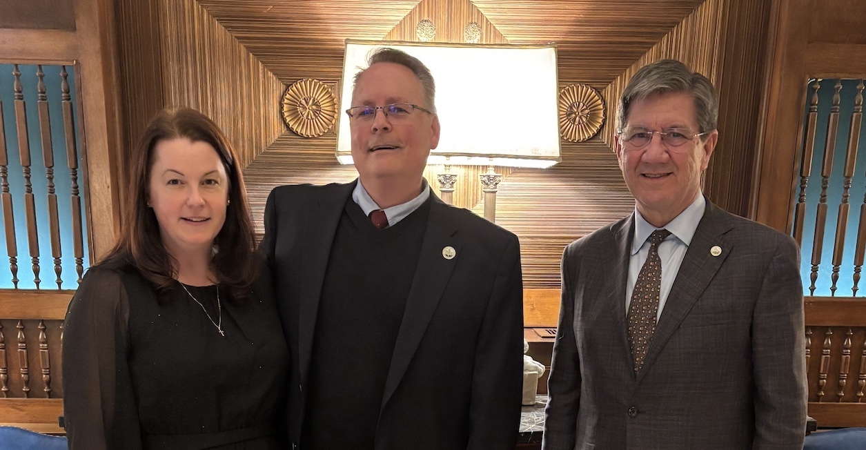 woman and two men stand in line