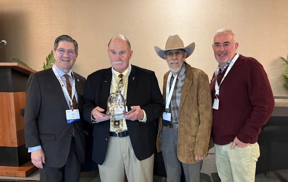 Four men stand in a line. 