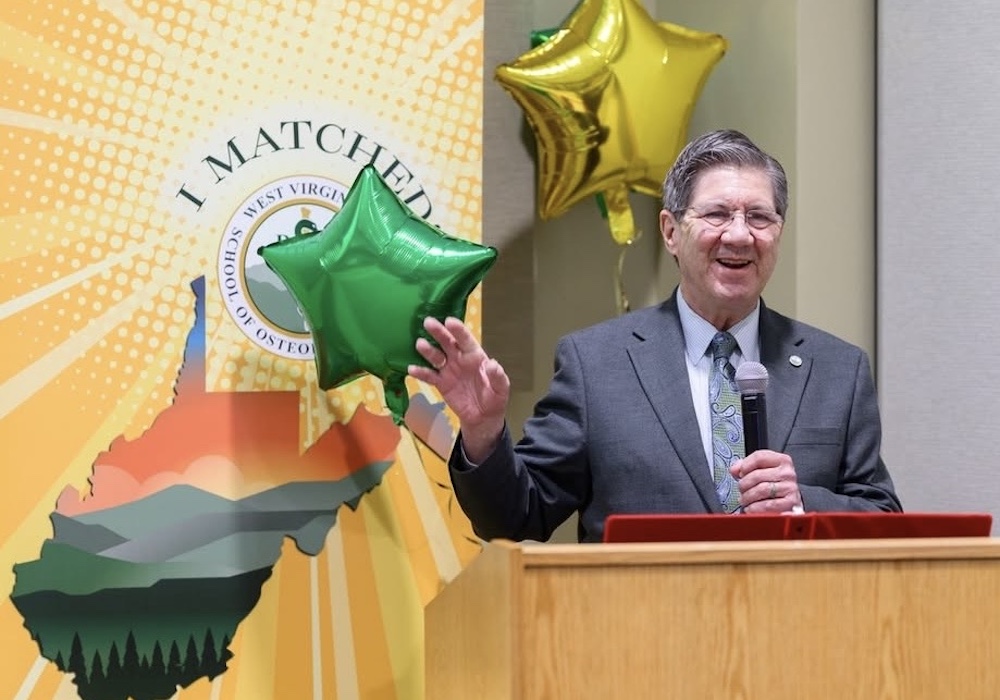 Man standing near balloon and sign