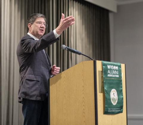 Man in suit speaking at podium. 