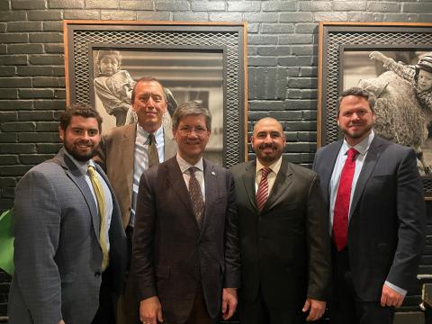 Five men in suits stand in a row.