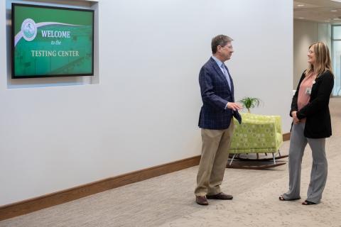 Man and woman stand talking in a big room