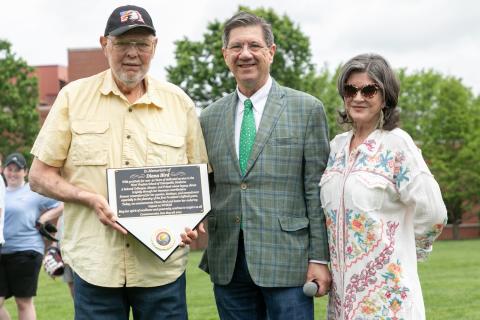 Two men and woman. One man is holding a plaque.