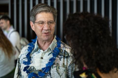 Man in beach shirt talking to a person