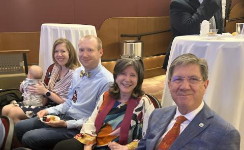 woman with baby, man, woman and man sit at an event