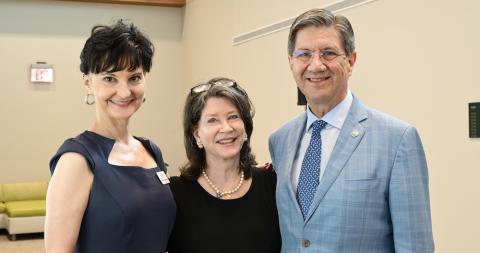 two women and man stand together