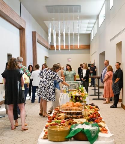 People in a crowded room enjoying food. 