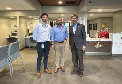 Three men stand in a medical Clinic.