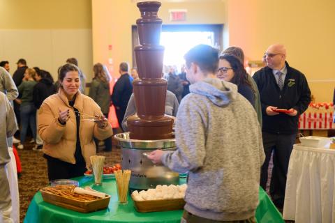 People stand around foundation pouring chocolate