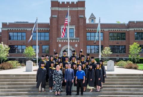 large group of people on steps in caps and gowns. 