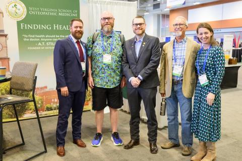 Four men and a woman stand in line. 
