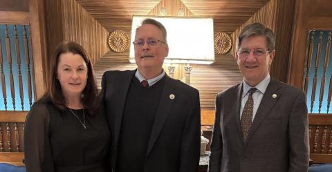 woman and two men stand in line