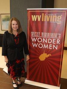 Woman stands next to a banner