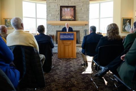 Man stands at a podium and talks to a crowd