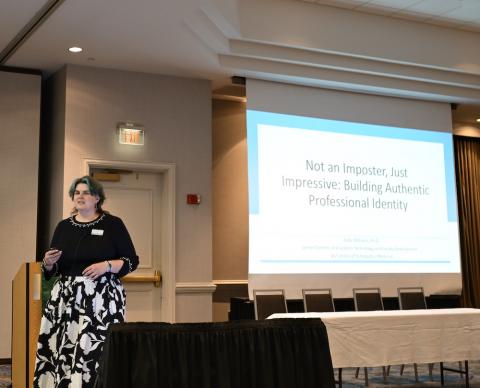 woman speaks near a screeen