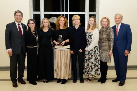 Eight people line up for an award presentation