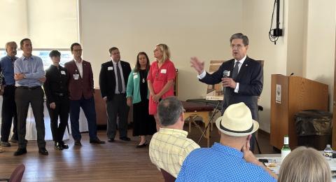 Man with microphone speaks to a crowd of business people