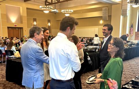 Group of people stand in a circle talking