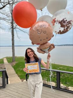 Woman holding sign and balloons